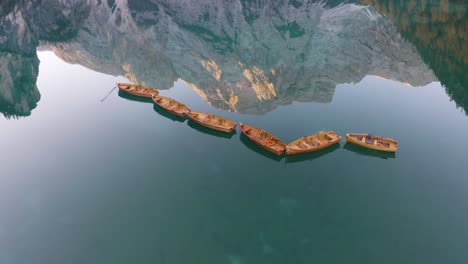 Escena-Cinematográfica,-Botes-De-Remos-De-Madera,-Lago-Braies,-Increíble-Reflejo-De-Montaña-En-El-Fondo