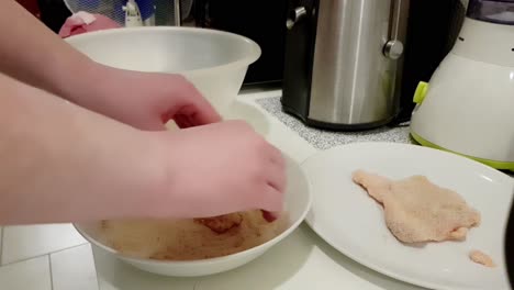 Caucasian-woman-breading-pork-meat-to-create-traditional-Hungarian-breaded-pork-slices