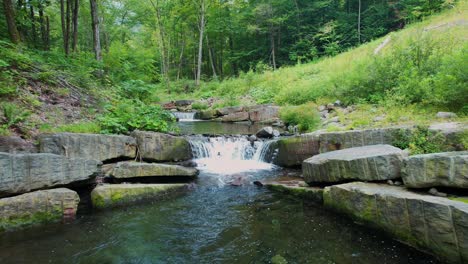 Drone footage of a beautiful little waterfall stream deep in the Appalachian mountains on a warm, green summer&#039;s day