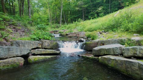 drone footage of a beautiful little waterfall stream deep in the appalachian mountains on a warm, green summer's day