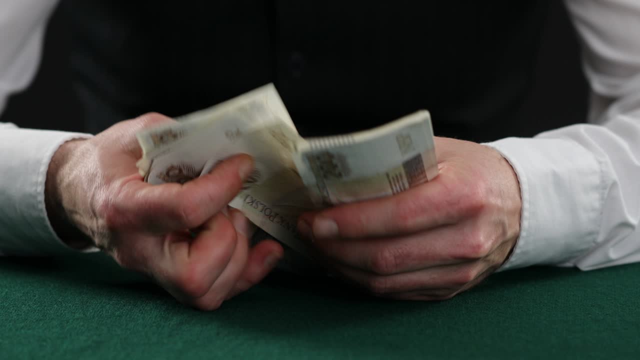 Mand tæller polske Zloty på et bord. En mand i forretningsskjorte tæller polske penge. Mandens hænder tæller polske pengesedler.