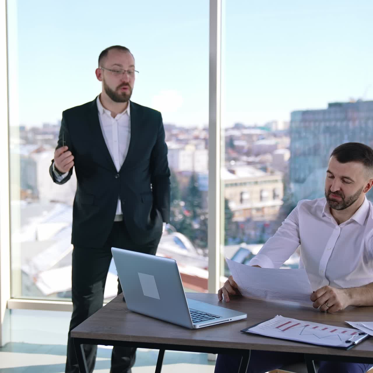 Business meeting in office room. Male entrepreneurs speaking about new business plans in office. Successful employees working indoors