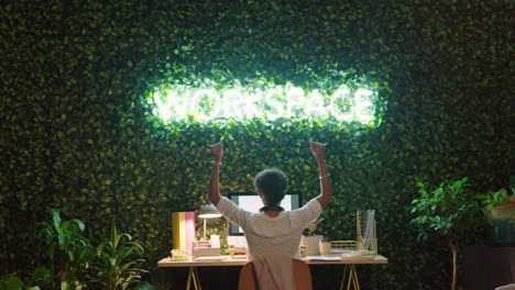 mujer de negocios trabajando hasta tarde en la oficina por la noche celebrando el éxito del proyecto fecha límite empresario disfrutando del éxito brazos levantados