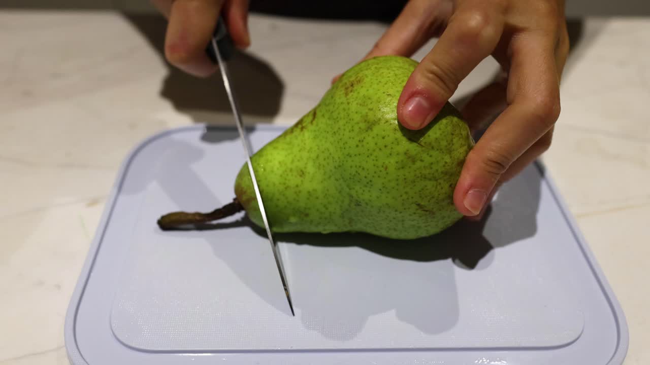 손이 칼로 진주를 잘라내는 것