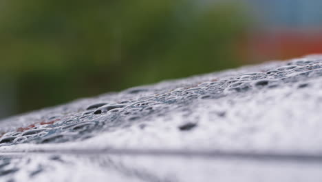 macro close up shot of raindrops falling on car in slow motion