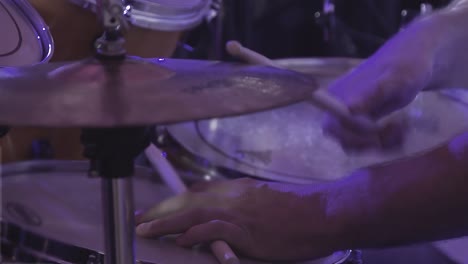 drummer plays percussion instruments at a concert as part of a musical group