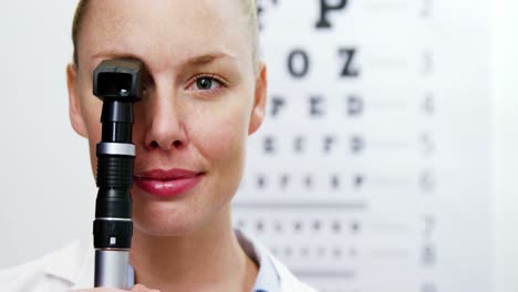 female optometrist holding ophthalmoscope