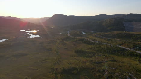 Aerial-shot-of-a-mountain-range-and-nature-reserve-at-sunset-in-Scandinavia