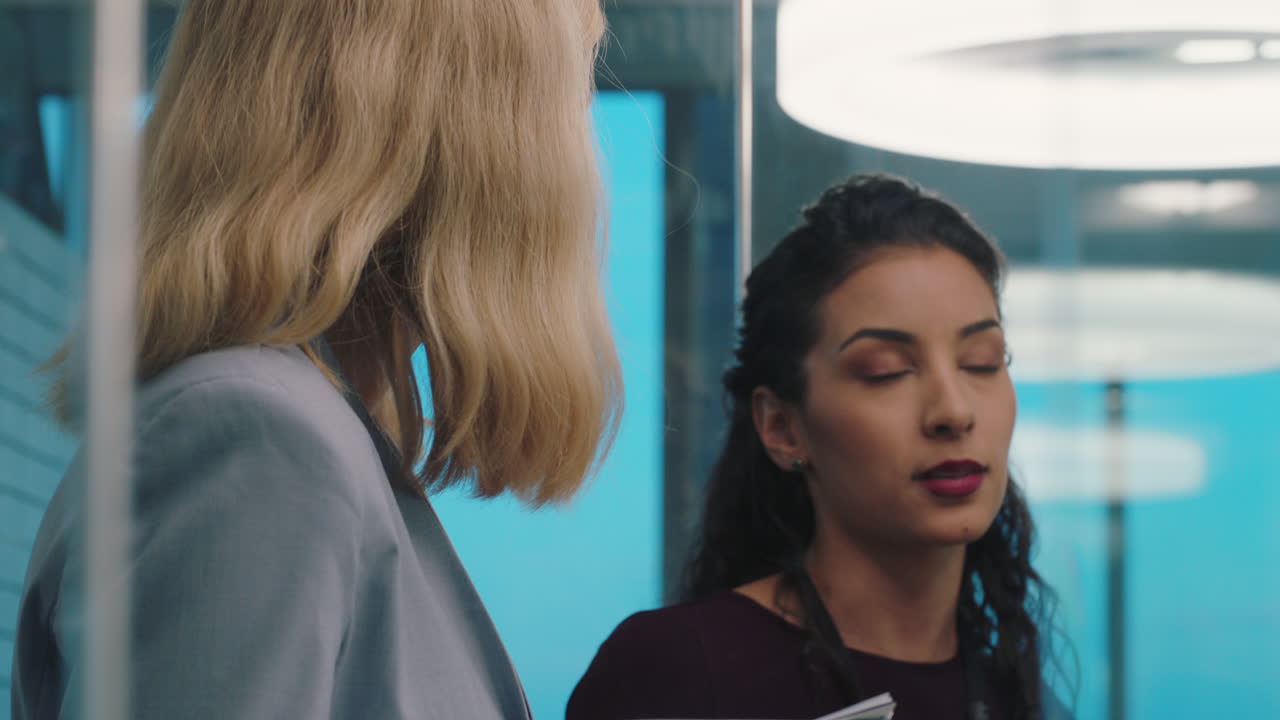 personas de negocios que se reúnen haciendo una lluvia de ideas dos ejecutivas que trabajan en estrategia discutiendo ideas en una oficina ocupada