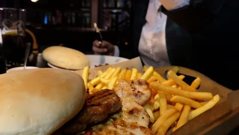 slow motion, close-up on woman eating in restaurant, oriental delicious food and french fries