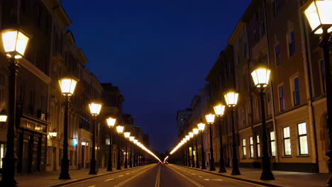 long city street at night lined with illuminated streetlights