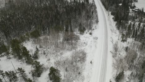 A-quiet-serene-winterscape-of-a-train-rail-system-cutting-through-the-frozen-Canadian-boreal-forest