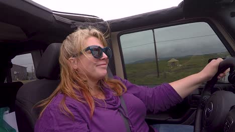 woman driving suv with the top down and smiling