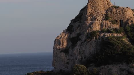 inclinarse hacia abajo disparar de una cumbre de montaña rocosa sobre el mar mediterráneo con aves volando alrededor