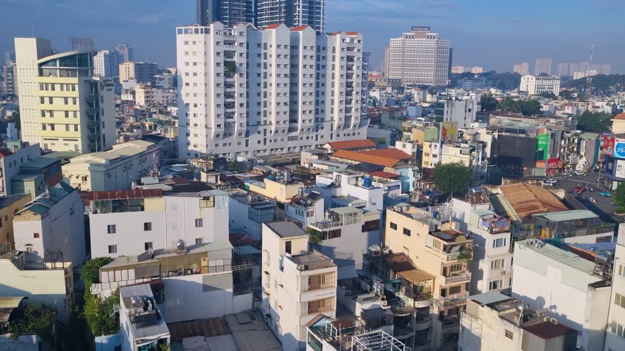 Revealing aerial shot over the rooftops of Saigon (Ho Chi Minh City) on a bright, sunny morning, showcasing the sprawling urban landscape