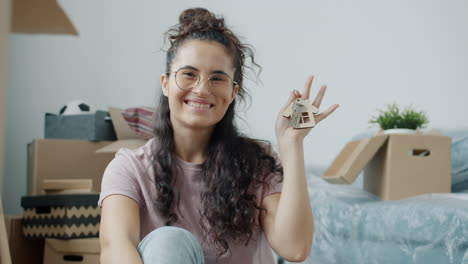 happy woman with house keys in moving box background