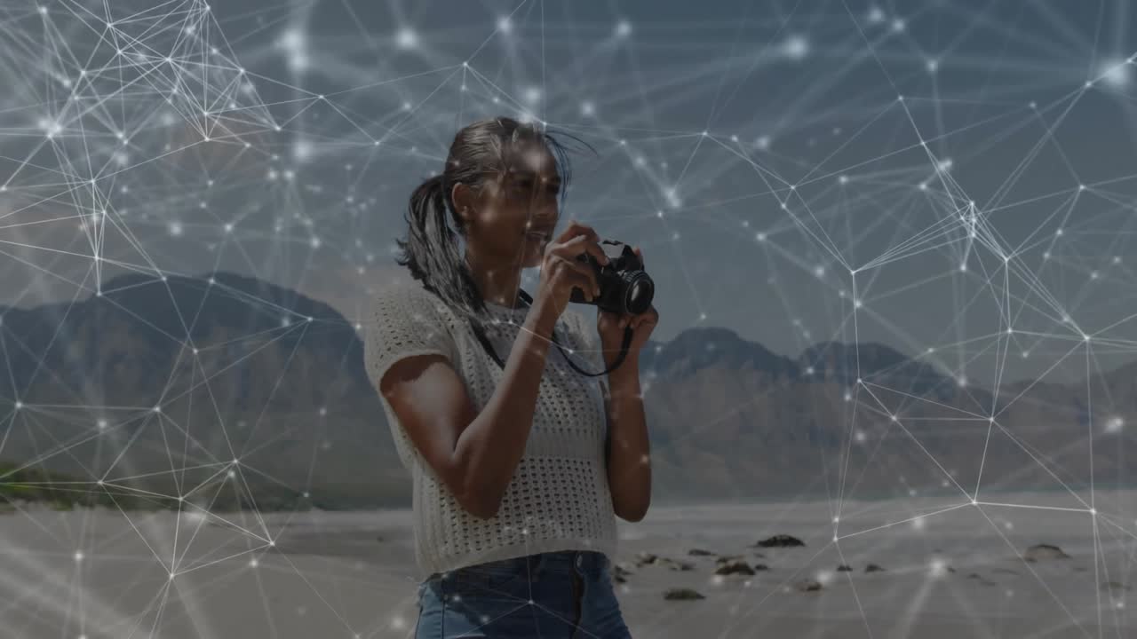 woman capturing sea view with camera, showcasing technology via digital network overlay