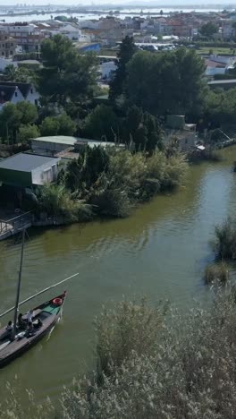 Traditional boat navigating a river through a village