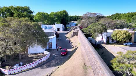 Aerial-view-of-small-neighborhood-street-and-city-fortification,-Colonia-del-Sacramento,-Uruguay