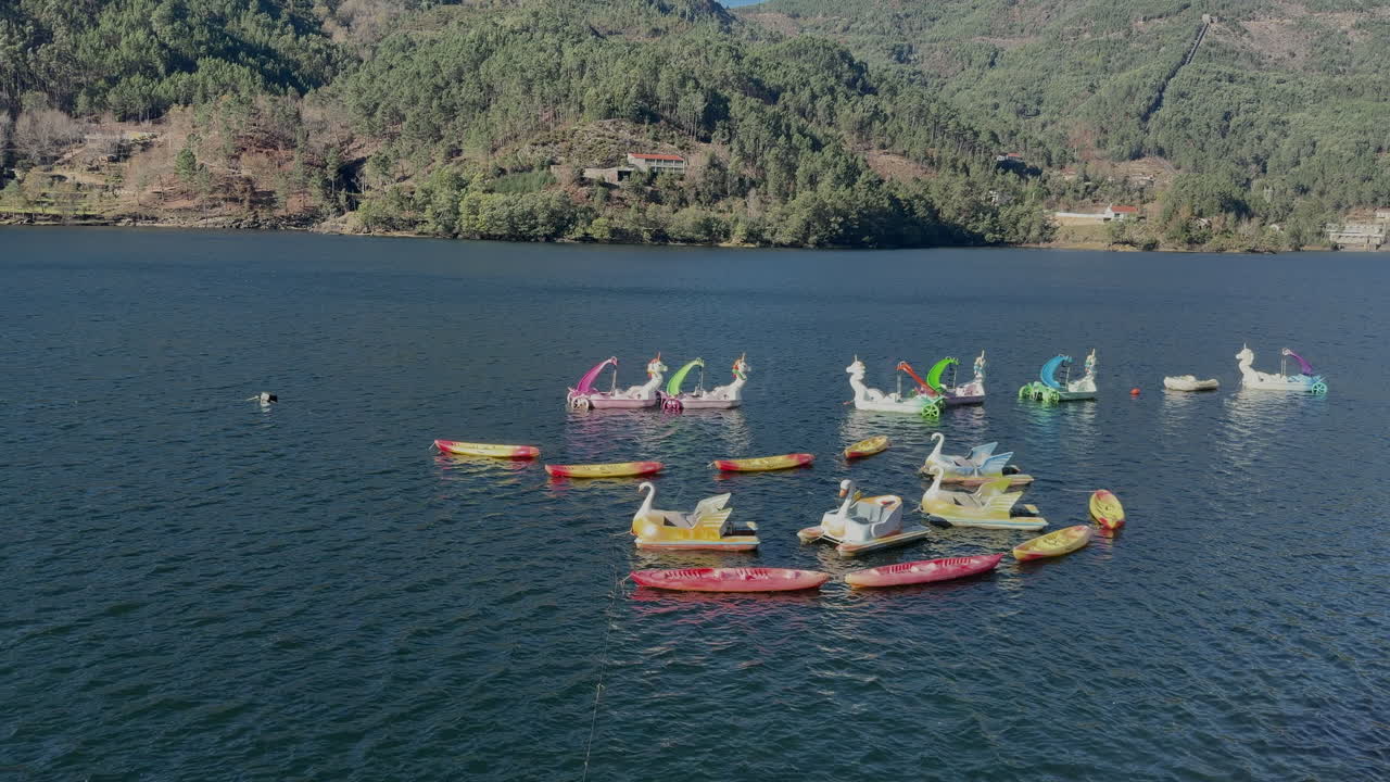Vista aerea con drone di colorate barche a pedali che galleggiano sul lago a Geres, Portogallo