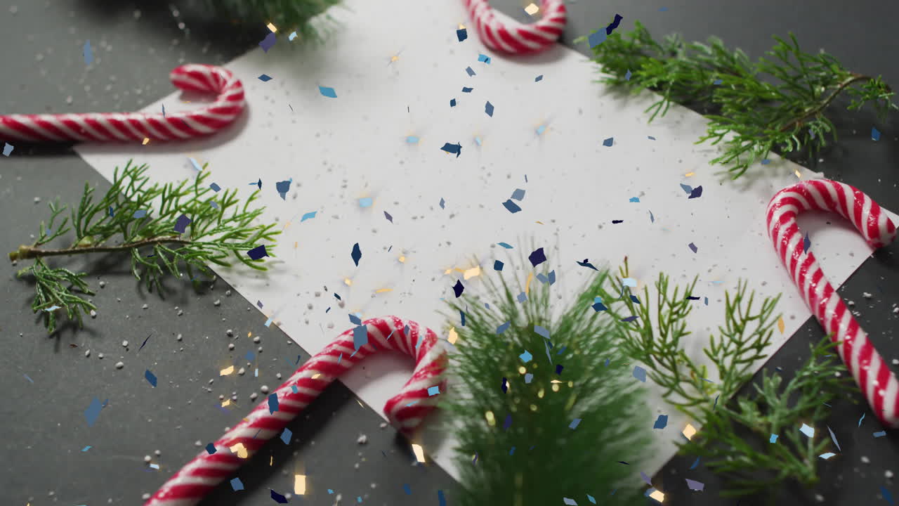 Animation of christmas decorations with card with copy space over confetti on grey background