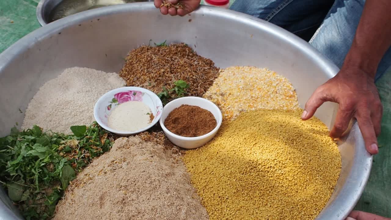 múltiples ingredientes en una sartén de metal para alimento nutritivo para pollos, disparados hacia atrás