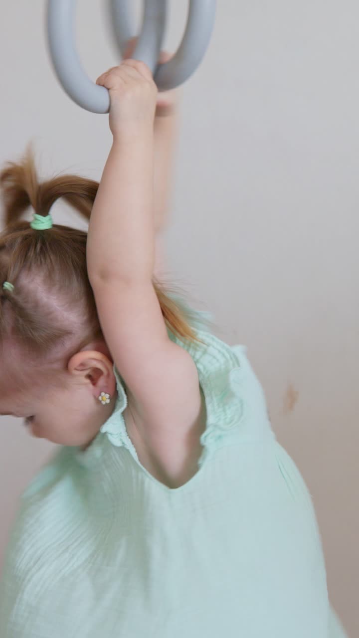 Young Girl Swinging on Indoor Gymnastic Rings