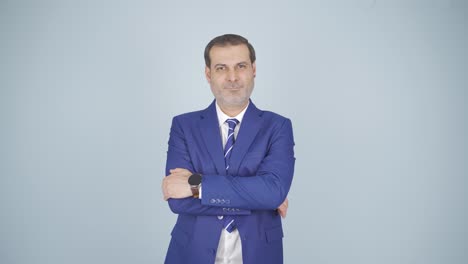 hombre de negocios con los brazos cruzados y riéndose de la cámara.