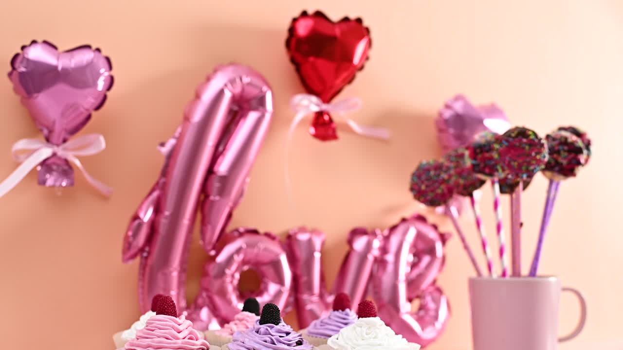 mesa de día de san valentín con postres dulces pastel pops y pasteles con cremas rosa pastel y púrpura claro y amor y globos de corazón detrás