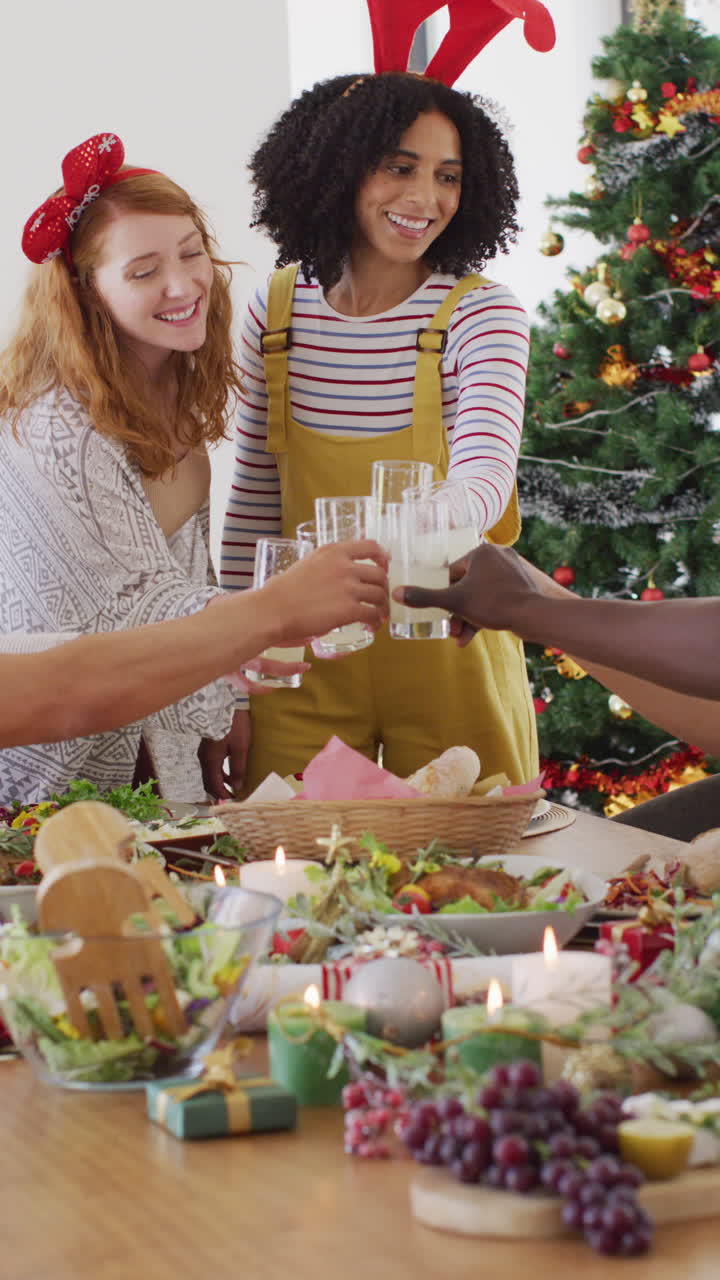 video vertical de un grupo de amigos diversos sentados a la mesa y cenando juntos