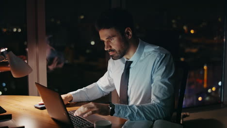 busy night office worker looking on laptop monitor worried deadline close up.