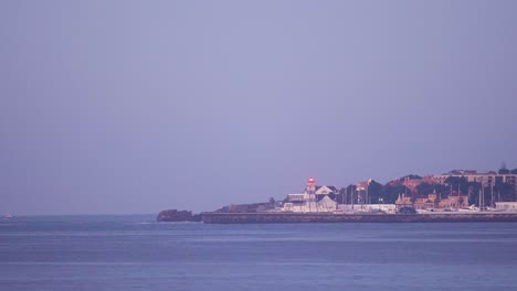 aerial view of cascais city in portugal, drone fly above coastline with beach lighthouse and harbour
