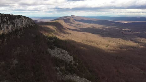 drone flyover catskill mountains with beautiful cloud shadows on a rocky cliff