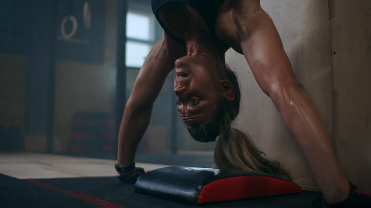 Training vertical push-ups intense strength exercise in closed gym. Woman doing vertical push-ups workout