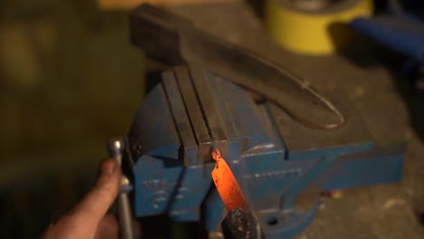 blacksmith working hot metal in vise
