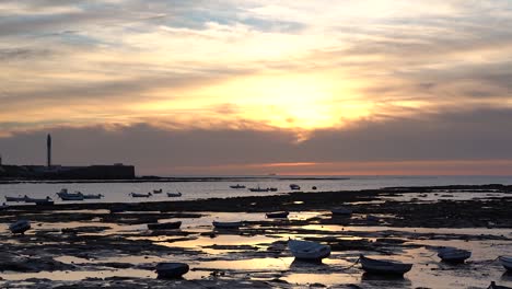 Langsamer-Schwenk-über-Die-Silhouetten-Kleiner-Fischerboote-Bei-Sonnenuntergang