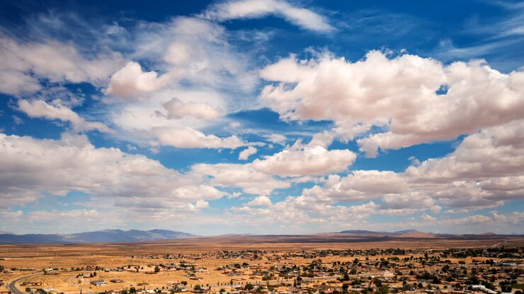 Lapso de tiempo con paneo de un dramático paisaje de nubes sobre California City en la cuenca del desierto de Mojave