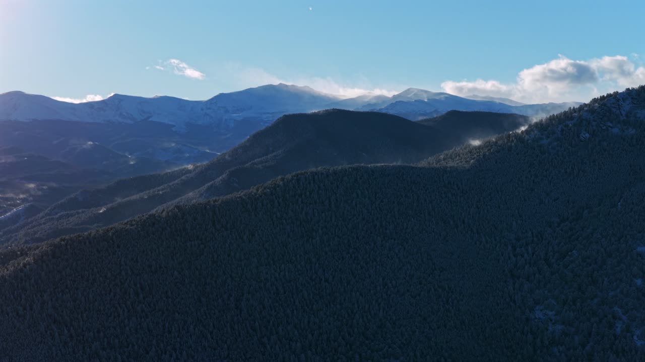 Snow covered Mount Blue Sky Mt Evans wind blown Bergen Peak Elk Meadow Park sunny sunset Evergreen Colorado aerial drone blue sky foothills valley forest Front Range Rocky Mountains circle left motion