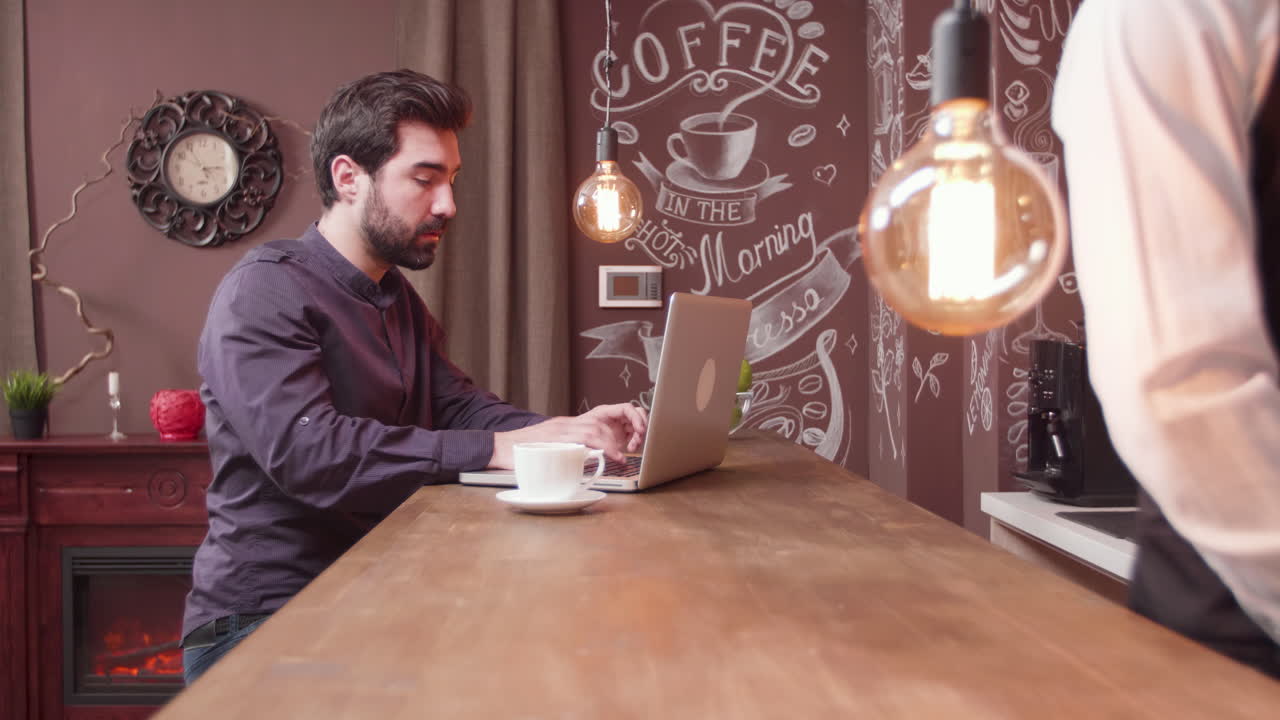 Uomo che lavora al computer portatile in un caffè