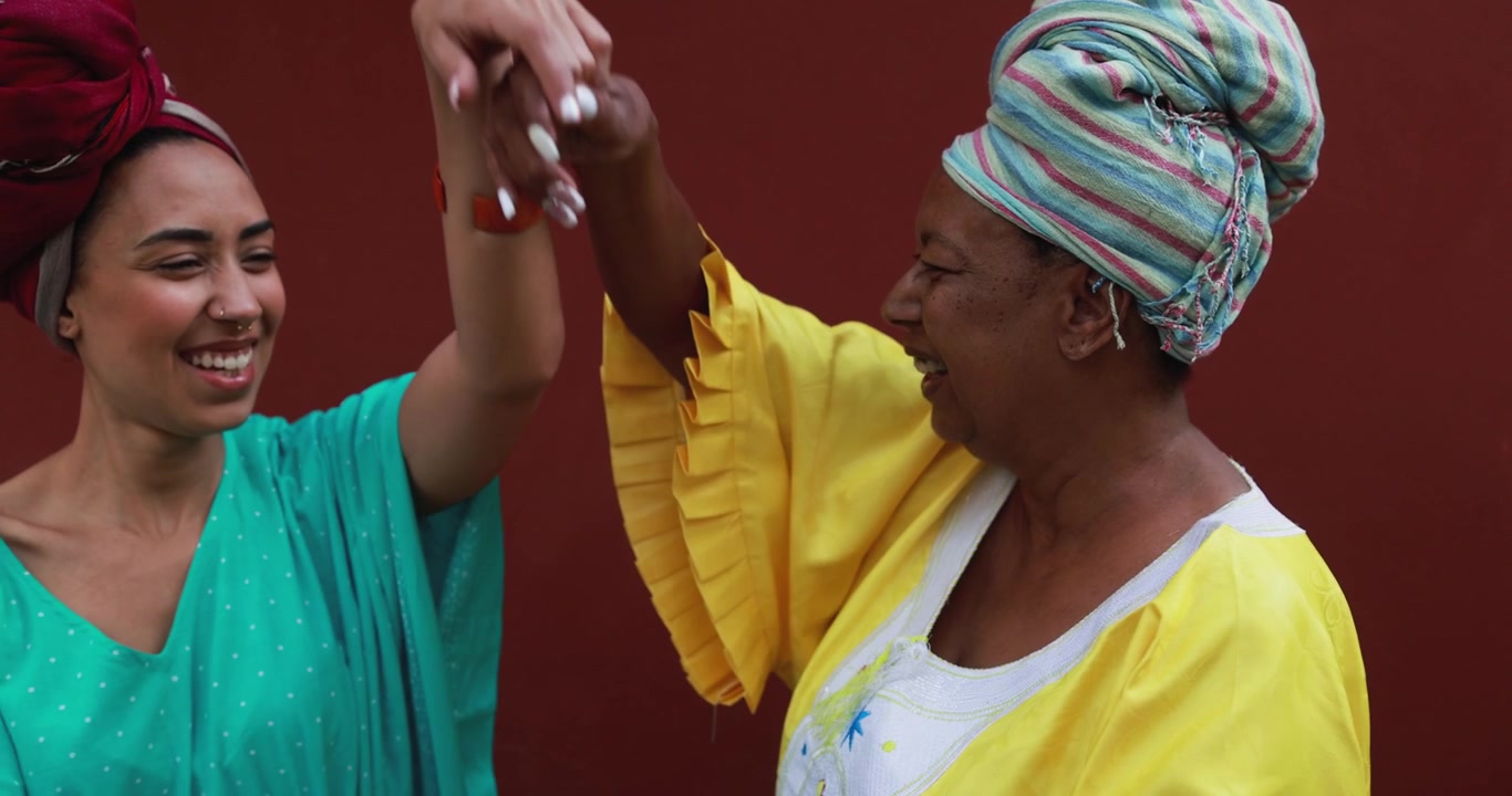 Two Happy African Women in Traditional Attire Dancing
