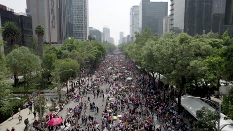 backwards drone shot of people congregated to celebrate pride parade in mexico city