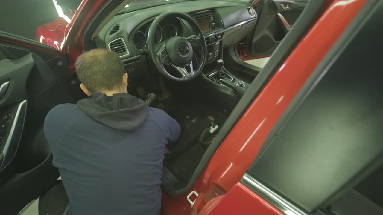 Professional car cleaning. Сar wash. Interior detailing. Dry clean and detail a car interior. Deep seats cleaning. Wiping foam in car wash. Cleaning the car panel from dust. A vacuum cleaner