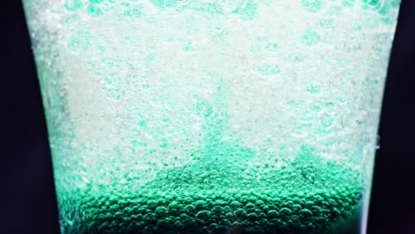 macro-shot-of-sparkling-blue-bubbles-moving-up-in-a-glass-with-bright-background