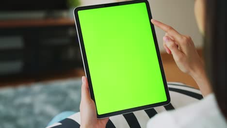 close up de mujer sosteniendo en las manos una tableta digital con pantalla verde para internet en línea, pantalla clave de croma para publicidad.