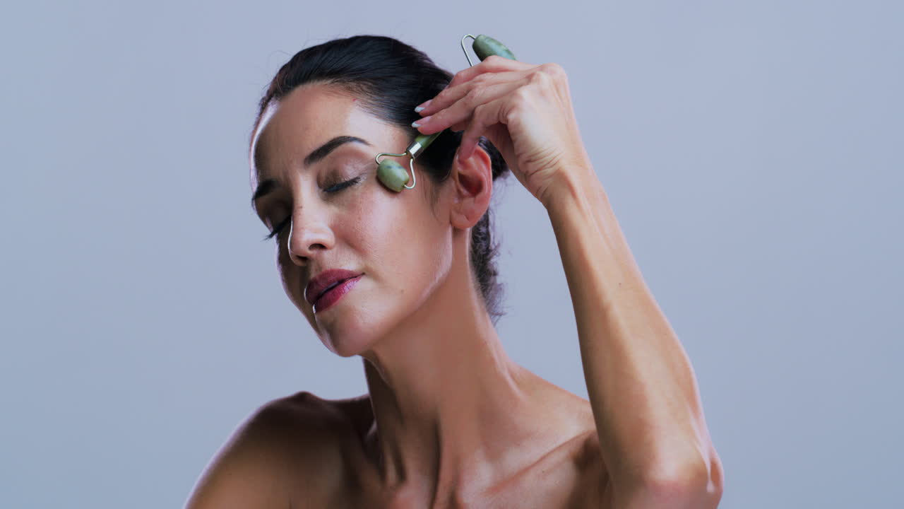 Woman using a jade roller for facial massage