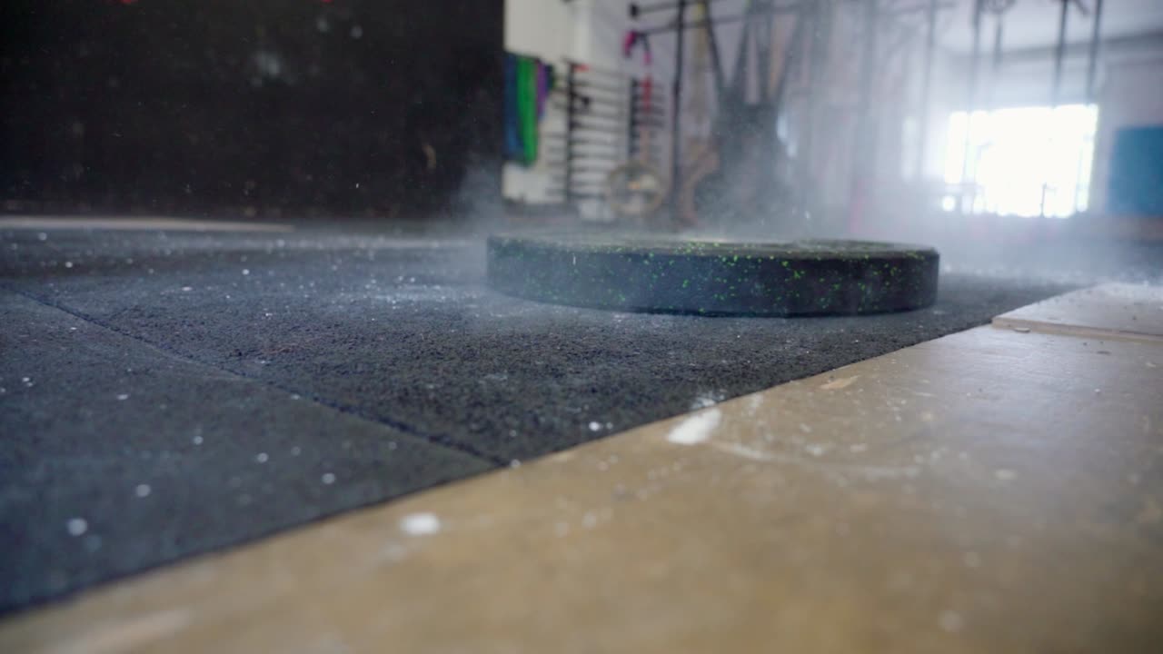 Weight plate dropping onto a gym floor after lifting