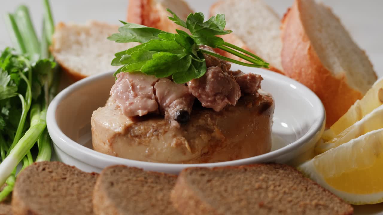 Smoked cod liver in oil in open tin can with fresh greens on wooden table. Seafoods delicacy. High quality 4k footage