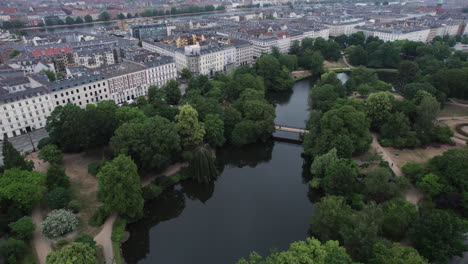 Una-Vista-De-Pájaro-Captura-La-Belleza-Natural-De-Ørstedsparken,-Ya-Que-Coexiste-Armoniosamente-Con-El-Paisaje-Urbano,-Ofreciendo-Vegetación-Y-Lagos-En-El-Centro-De-Copenhague