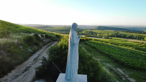 estatua de maría rezando en una colina con hermosas vistas aéreas del paisaje