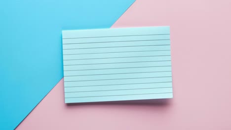 blank lined note card on blue and pink background